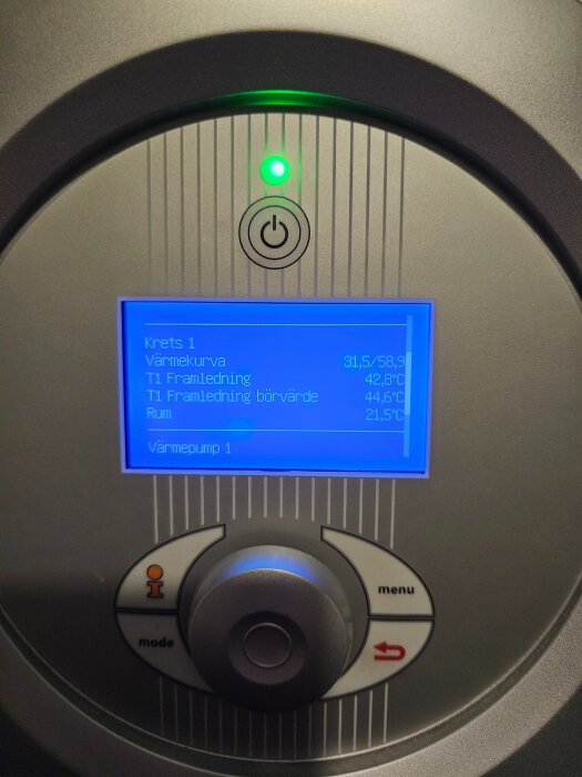 Display på bergvärmepump visar temperaturer och värmekurva; grönt ljus och kontrollpanel synliga.