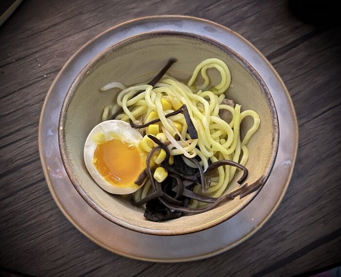 Halv portion Tonkotsu Ramen med fläsk chashu, marinerat ägg, kikurage, böngroddar och vårlök i en skål.