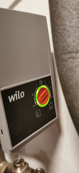 Grå Wilo pumpregulator med orange vridknapp och grön lampa, inställd på nivå 3.