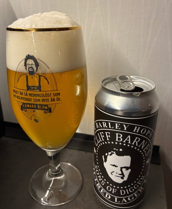 Ölglas med skumhaltig lager från Cliff Barnes "Sons of a Digger", etikett med tecknad mansbild och text om meningslöshet utan öl.