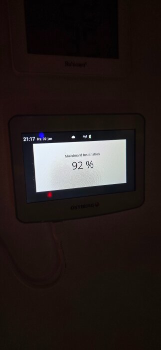 Bild av en skärm som visar "Mainboard Installation 92 %" med datum och tid ovanför.