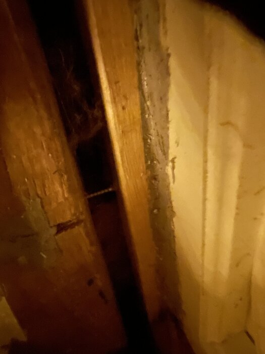 Glipa mellan regel och timmervägg med synlig isolering, inomhusbild i ett timmerhusunder renovering.