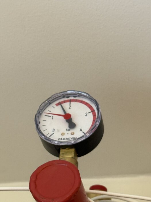 Manometer med visaren på 1,2 bar, monterad på röd ledning.