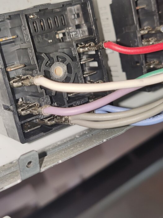 Närbild av elektrisk koppling med flera färgade kablar anslutna till en effektregulator, del av en spisreparation.