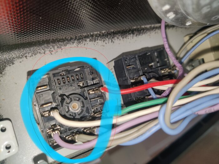 Närbild på två elektriska effektregulatorer med färgkodade kablar, där en av regulatorerna är markerad med en blå cirkel.