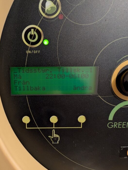 Närbild av en värmepumps digitala display som visar tidsstyrning inställd för tillskott mellan 22:00 och 06:00, med en grön lysdiod tänd.