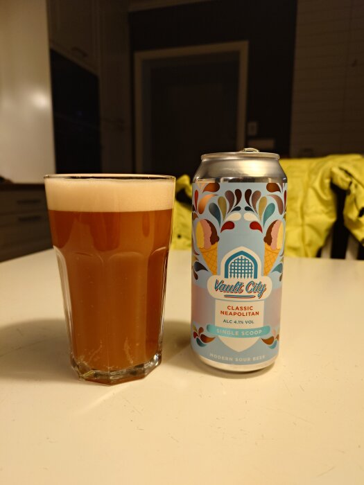 En burk öl med etiketten "Vault City Classic Neapolitan" och ett glas öl står på ett bord.