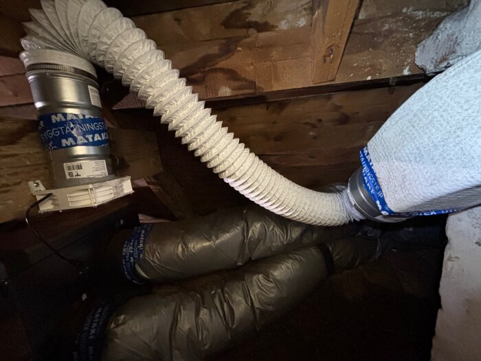 Ventilationsrör och kopplingar installerade på plats i en träkonstruktion.