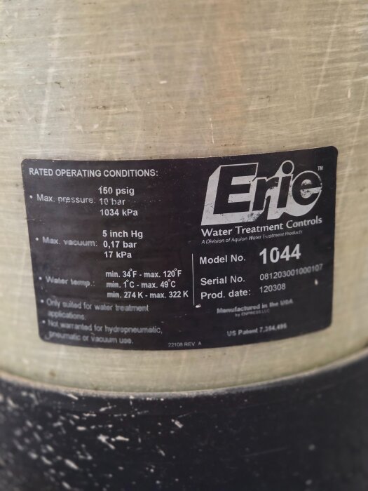 Närbild av en etikett på ett Erie vattenfilter, modell 1044, med tekniska specifikationer som tryck och temperaturintervall.