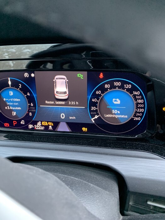 Instrumentbräda i VW Golf Hybrid med visad laddningsstatus på 50%, återstående laddtid 3:35 timmar och detaljerad körinformation.