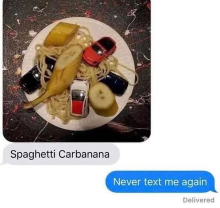 Tallrik med spaghetti, leksaksbilar och bananskivor; textmeddelande "Spaghetti Carbanana" följt av "Never text me again".