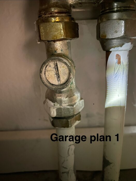 Cirkulationsrör och ventil i garaget på kedjehus plan 1, med text "Garage plan 1" skriven på bilden.