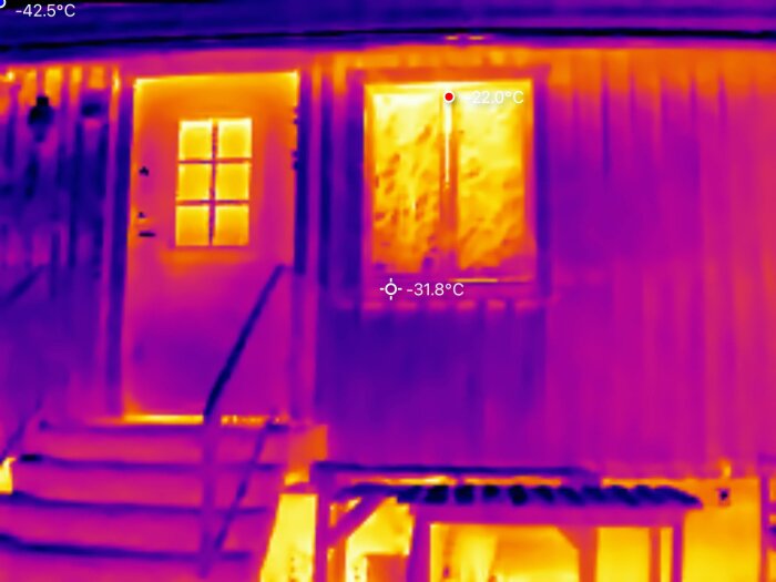 Termisk bild av ett hus med synliga temperaturvariationer på fasad, dörr och fönster. Temperaturen visas som -31,8°C och +22,0°C.