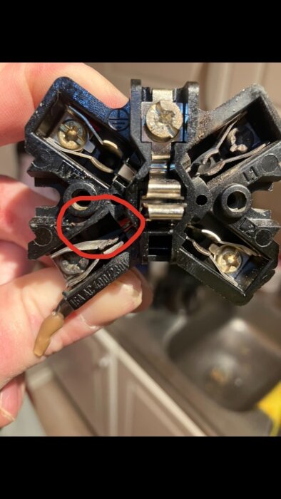 Bränt spisuttag med skadat L3 stift och kontaktbleck. Inringat område visar där stiftet missar blecken.