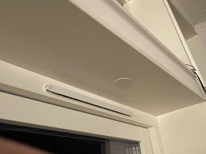 Spotbelysning installerad i fönstersmyg utan synligt drivdon, med en impulsfjäderknapp för dimring och synlig kabeldragning.
