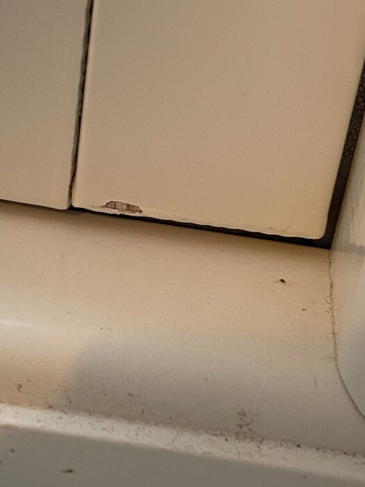 Närbild av fönsterkarm med tecken på skador och light kondens uppbyggd på ytan, potentiellt relaterat till fuktproblem i nyproducerad bostad.
