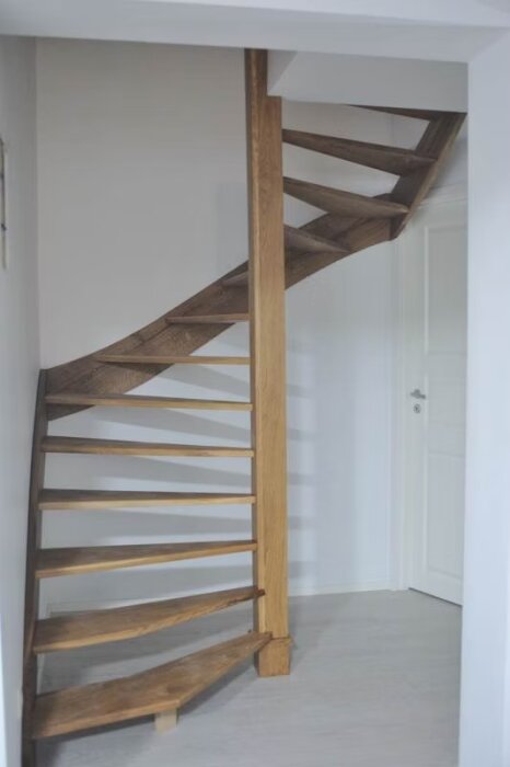 Träspiraltrappa i modern inomhusmiljö, enkel design, byggd utan professionell verkstad.