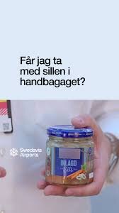 Person håller en burk med inlagd sill och en text som frågar om den får tas med i handbagaget.