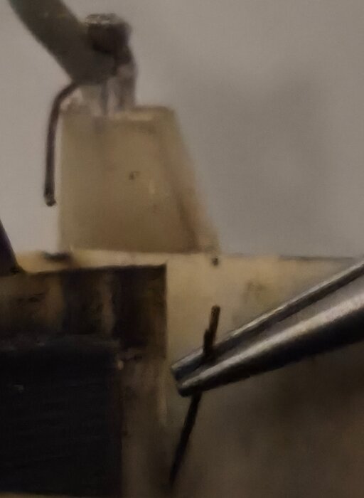 Osäker zoomad bild av verktyg och sladdar på en arbetsyta.
