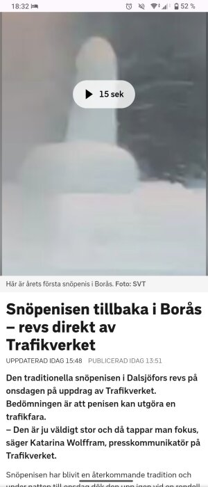 En snöskulptur i form av en stor snöpenis står utomhus i en snötäckt omgivning.