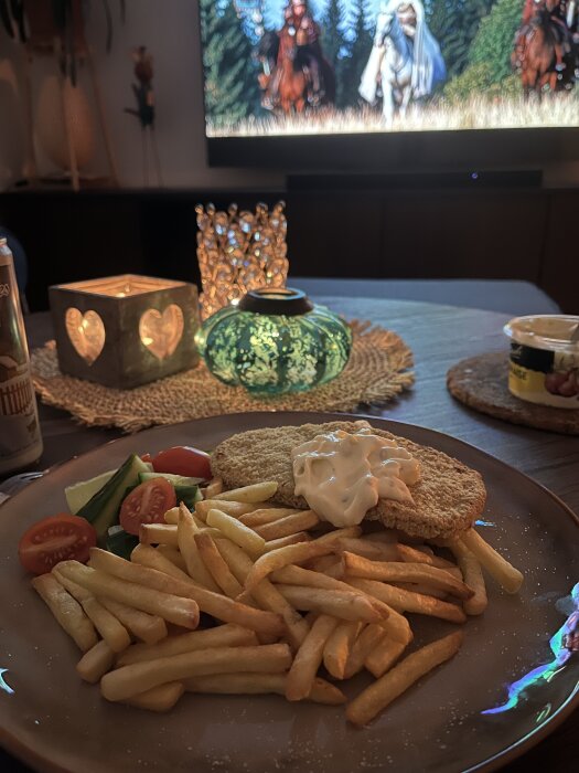 En tallrik med schnitzel, pommes frites, grönsaker och bearnaisesås. En tänd ljuslykta och en tv visar filmen "Eragon" i bakgrunden.