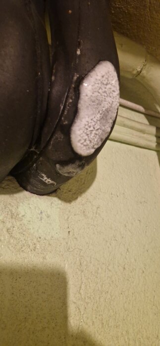 Kondensationsis på en bergvärmerörsinstallation på en vägg, som är 8 år gammal, med vit frostbildning på ytan.