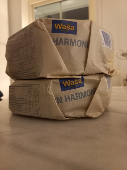 Två förpackningar Wasa hårdbröd staplade på ett bord, med texten "HARMONI" synlig på paketen.