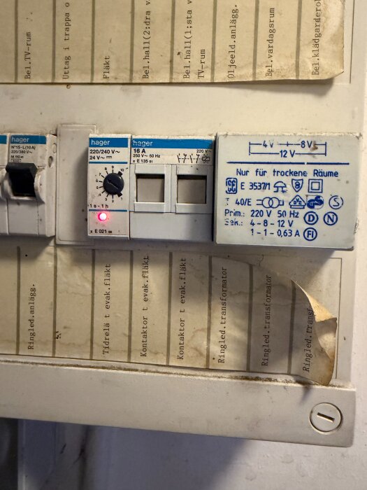 Elcentral med Hager tidsrelä och kontaktorer, märkta med 220/240V, och etiketter för olika funktioner som fläkt och transformator.