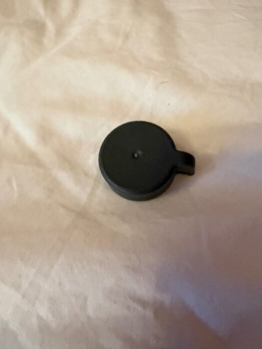 Svart plastkopp på beige yta, använd för att reglera Manuel och Auto-inställningar på en grå E&D plastmatta.