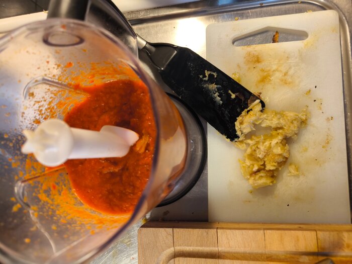 Mixer med grillad paprika och mosad vitlök på skärbräda, redo för chorizogryta.