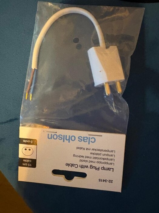 Förpackning med en lampkontakt med plastkåpa och tvåpolig kabel.