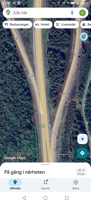 Satellitbild över en 2+1-väg med påfart, omgiven av skog, med markerade riktningspilar och en E4-skylt.