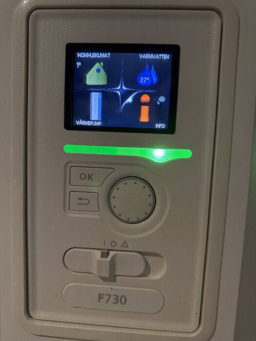 Kontrollpanel för Nibe F730 värmepump med display som visar temperaturinställningar och meny.