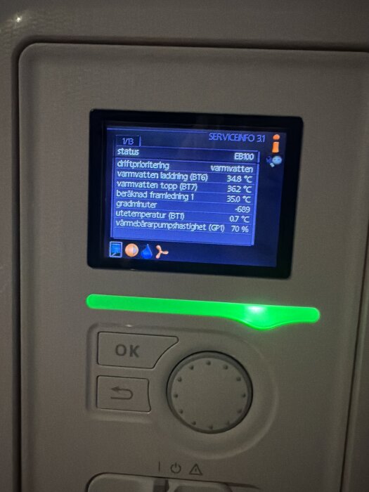 Display på Nibe F730 värmepump visar driftsstatus, inklusive varmvattenladdning, temperaturer och gradminuter.