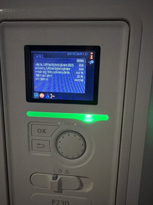 Display på en Nibe F730 värmepump, visar serviceinformation som luftfuktighetsvärden, minskning från referensvärde och fläkthastighet.