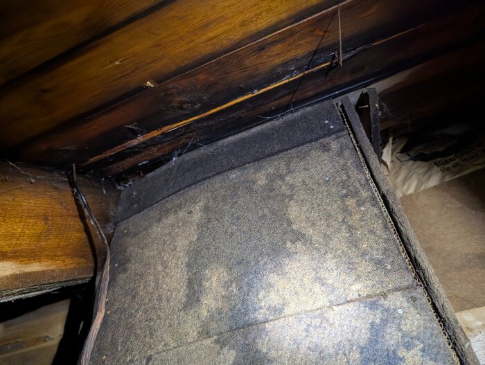 Vind med fuktigt råspont och misstänkt svartmögel vid isolering. Saknad ventilation och bristande isolering i taket.