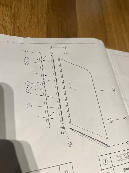 Monteringsanvisning med detaljerad ritning av delar för glasvägg till badkar. Numrerade delar med fokus på väggfäste och installationsdetaljer.