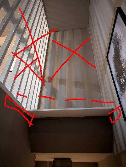 Vy från trappräcke mot oisolerat kallförråd, röda kryss och linjer markerar föreslagen golvlösning ovanför trappa för ombyggnad till sovrum.