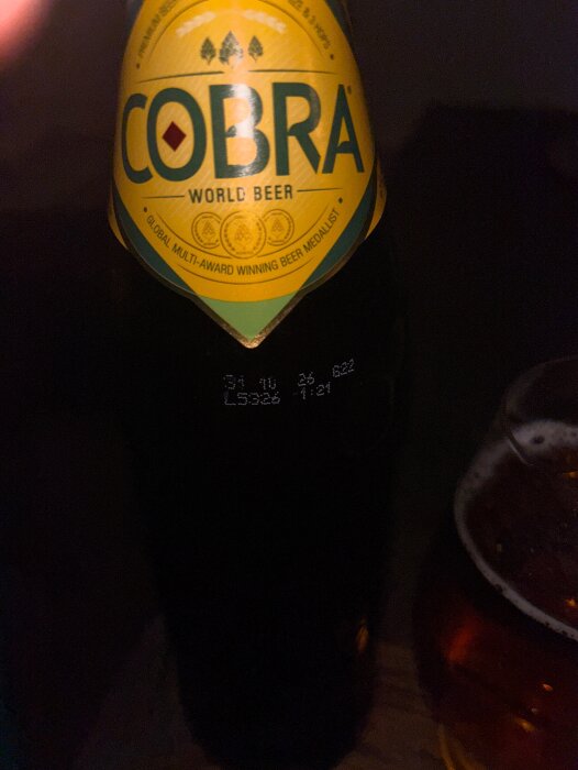 Flaska med Cobra öl bredvid ett glas med öl.
