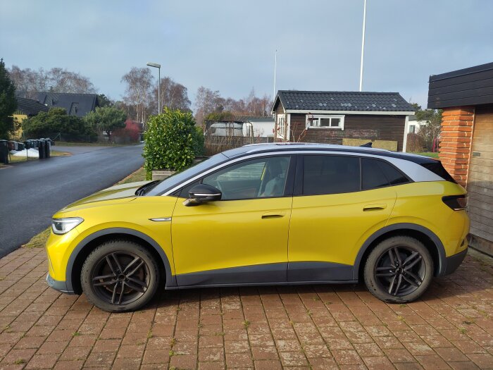 Gul bil parkerad på uppfart, redo för verkstadsbesök. Rentvättad med avfettning och Turtleschampo med vax.