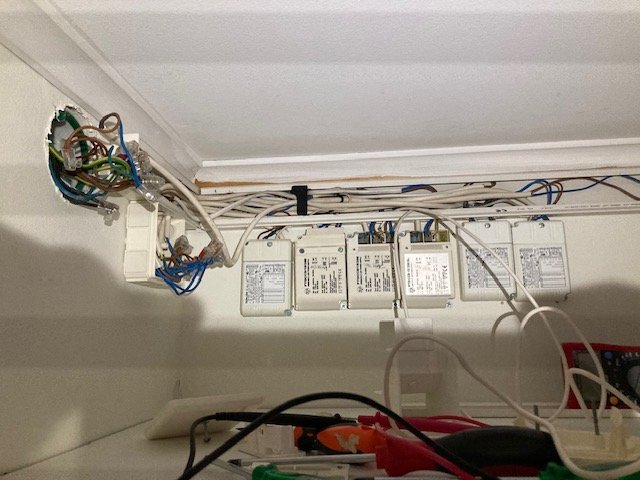Drivdon installerade på en vägg, flera elektriska kablar är anslutna, två drivdon ses i mitten, övriga don i bakgrunden.