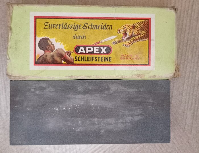 Tysk slipsten i originalförpackning med etikett som visar texten "Apex Schleifsteine" och en illustration av en leopard.