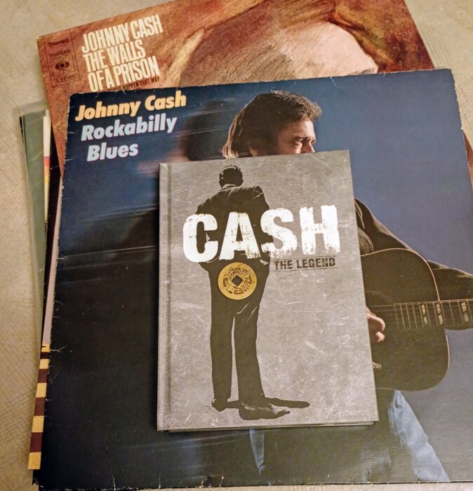 Böcker och skivomslag av Johnny Cash på ett bord.