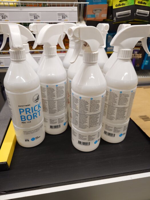 Flera flaskor av avfettningsmedel med etiketten "Prick Bort" står på en hylla i en butik, omgivna av andra rengörings- och rakprodukter.
