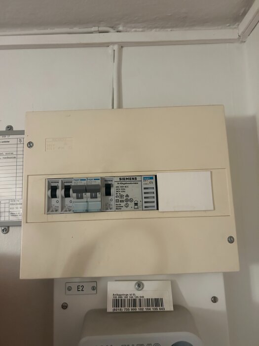 Elcentral med mätartavla och strömbrytare monterad på vägg, märkt Siemens och Hager, i tidigare tvättstuga.