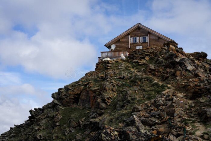 Trähus på en klippa med antenn på balkongen, perfekt för marknära vindkraft.