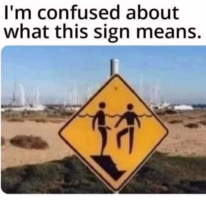 Gult vägskylt med två piktogram: en person i vatten, en annan går på en ramp ned i vattnet. Text ovanför: "I'm confused about what this sign means.