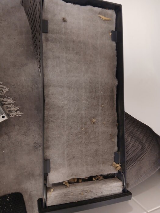 Luftfilter med synlig isolering fastnat i det, vilket kan tyda på problem med ventilationen.