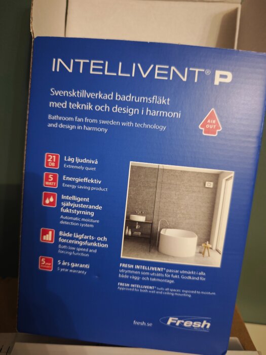 Förpackning av Intellivent P badrumsfläkt med specifikationer och bild på badrum. Fläkt lovar låg ljudnivå på 21 dB och har fem års garanti.