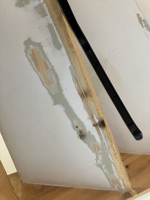 Renovering av trappa med avskrapade färglager och trädetaljer synliga, innan målning och bearbetning av träytor är avslutade.